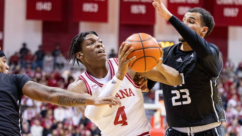 Dec 21, 2023; Bloomington, Indiana, USA; Indiana Hoosiers forward Anthony Walker (4) dribbles the ball as North Alabama Lions forward Tim Smith Jr. (23) defends in the first half at Simon Skjodt Assembly Hall. Mandatory Credit: Trevor Ruszkowski-USA TODAY Sports