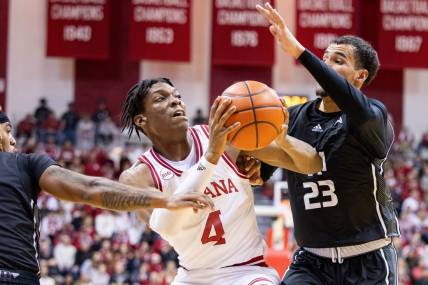 Dec 21, 2023; Bloomington, Indiana, USA; Indiana Hoosiers forward Anthony Walker (4) dribbles the ball as North Alabama Lions forward Tim Smith Jr. (23) defends in the first half at Simon Skjodt Assembly Hall. Mandatory Credit: Trevor Ruszkowski-USA TODAY Sports