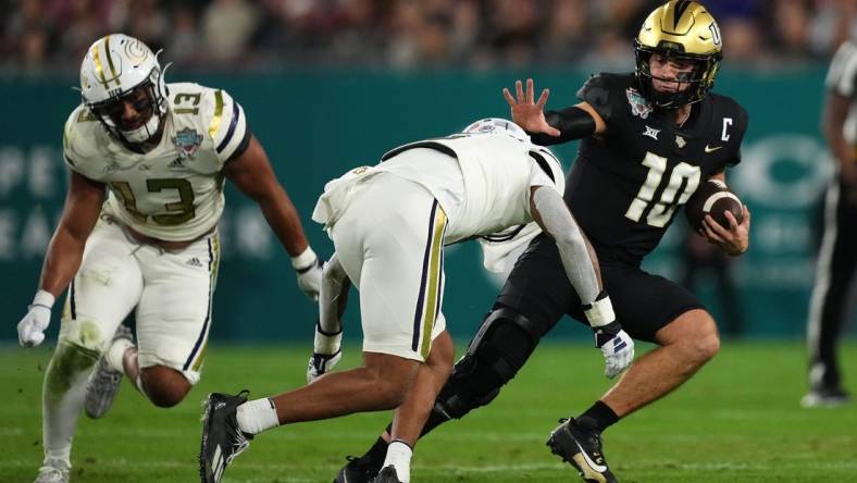 Dec 22, 2023; Tampa, FL, USA; UCF Knights quarterback John Rhys Plumlee (10) runs the ball around Georgia Tech Yellow Jackets defensive back Clayton Powell-Lee (5) during the first half of the Gasparilla Bowl at Raymond James Stadium. Mandatory Credit: Jasen Vinlove-USA TODAY Sports