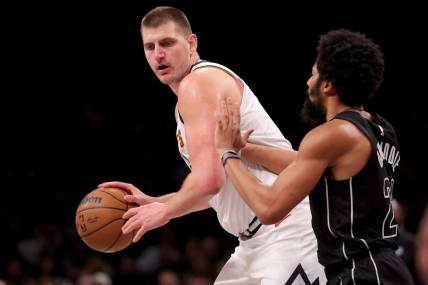Dec 22, 2023; Brooklyn, New York, USA; Denver Nuggets center Nikola Jokic (15) controls the ball against Brooklyn Nets guard Spencer Dinwiddie (26) during the second quarter at Barclays Center. Mandatory Credit: Brad Penner-USA TODAY Sports