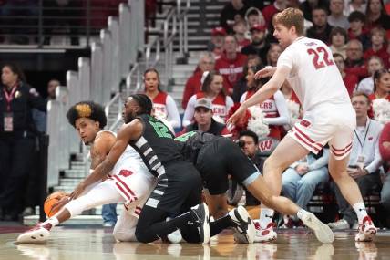 Dec 22, 2023; Madison, Wisconsin, USA; Wisconsin Badgers guard Chucky Hepburn (23) reaches a loose ball before Chicago State Cougars guard Brent Davis (12) as Chicago State Cougars forward Noble Crawford (15) and Wisconsin Badgers forward Steven Crowl (22) look on during the first half at the Kohl Center. Mandatory Credit: Kayla Wolf-USA TODAY Sports