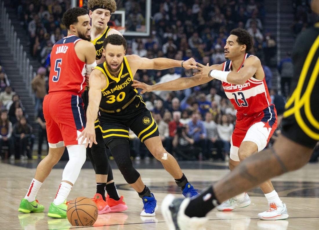 Dec 22, 2023; San Francisco, California, USA; Golden State Warriors guard Stephen Curry (30) dribbles away from pressure by Washington Wizards guard Jordan Poole (13) during the first quarter at Chase Center. Mandatory Credit: D. Ross Cameron-USA TODAY Sports