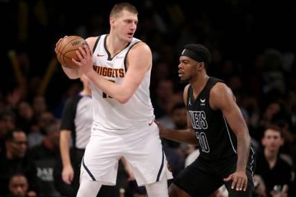 Dec 22, 2023; Brooklyn, New York, USA; Denver Nuggets center Nikola Jokic (15) controls the ball against Brooklyn Nets center Day'Ron Sharpe (20) during the fourth quarter at Barclays Center. Mandatory Credit: Brad Penner-USA TODAY Sports
