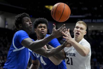 Dec 23, 2023; Cincinnati, Ohio, USA;  Seton Hall Pirates guard Kadary Richmond, left, center Elijah Hutchins-Everett, middle, and Xavier Musketeers forward Sasa Ciani, right, battle for a rebound in the first half at the Cintas Center. Mandatory Credit: Aaron Doster-USA TODAY Sports