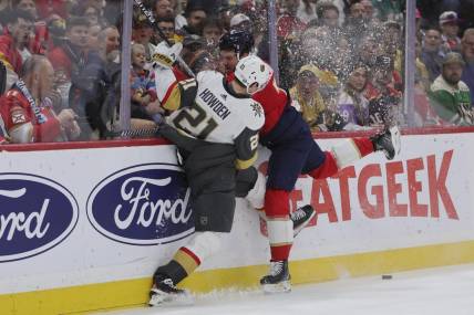 Dec 23, 2023; Sunrise, Florida, USA; Vegas Golden Knights center Brett Howden (21) and Florida Panthers defenseman Dmitry Kulikov (7) battle for the puck during the first period at Amerant Bank Arena. Mandatory Credit: Sam Navarro-USA TODAY Sports