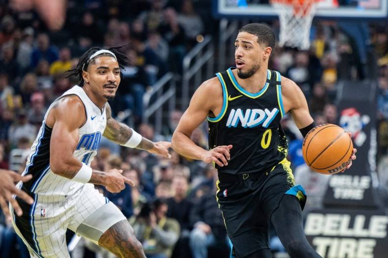 Dec 23, 2023; Indianapolis, Indiana, USA;  Indiana Pacers guard Tyrese Haliburton (0) dribbles the ball while Orlando Magic guard Gary Harris (14) defends in the first quarter at Gainbridge Fieldhouse. Mandatory Credit: Trevor Ruszkowski-USA TODAY Sports
