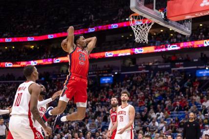 Dec 23, 2023; New Orleans, Louisiana, USA;  New Orleans Pelicans guard Trey Murphy III (25) dunks against Houston Rockets forward Jabari Smith Jr. (10) during the first half at Smoothie King Center. Mandatory Credit: Stephen Lew-USA TODAY Sports