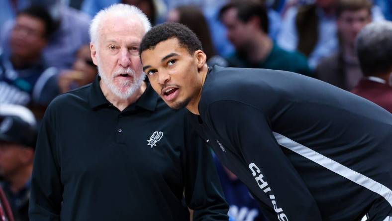 Dec 23, 2023; Dallas, Texas, USA; San Antonio Spurs head coach Gregg Popovich speaks with San Antonio Spurs center Victor Wembanyama (1) before the game against the Dallas Mavericks at American Airlines Center. Mandatory Credit: Kevin Jairaj-USA TODAY Sports