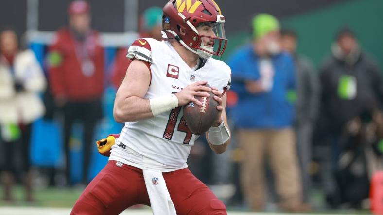 Dec 24, 2023; East Rutherford, New Jersey, USA; Washington Commanders quarterback Sam Howell (14) drops back to pass during the first quarter against the New York Jets at MetLife Stadium. Mandatory Credit: Vincent Carchietta-USA TODAY Sports