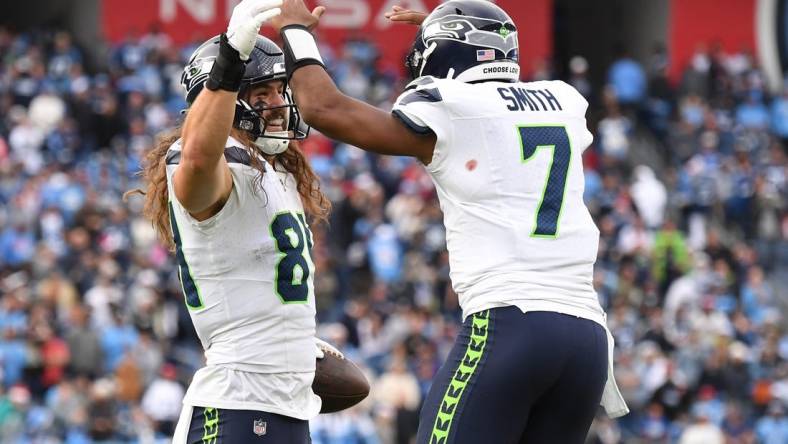 Dec 24, 2023; Nashville, Tennessee, USA; Seattle Seahawks tight end Colby Parkinson (84) celebrates with quarterback Geno Smith (7) after scoring the game-winning touchdown during the second half against the Tennessee Titans at Nissan Stadium. Mandatory Credit: Christopher Hanewinckel-USA TODAY Sports