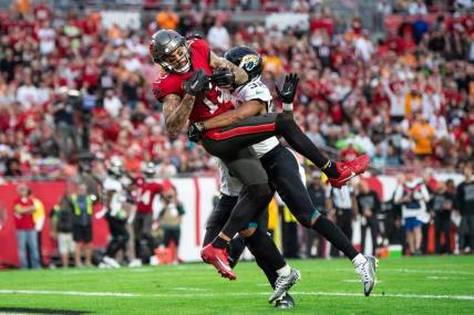 Dec 24, 2023; Tampa, Florida, USA; Tampa Bay Buccaneers wide receiver Mike Evans (13) makes the catch against Jacksonville Jaguars cornerback Tyson Campbell (32) in the second quarter for the touchdown at Raymond James Stadium. Mandatory Credit: Jeremy Reper-USA TODAY Sports
