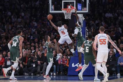 Dec 25, 2023; New York, New York, USA; New York Knicks guard Immanuel Quickley (5) drives to the basket as Milwaukee Bucks forward Bobby Portis (9) and guard Damian Lillard (0) defend during the second half at Madison Square Garden. Mandatory Credit: Vincent Carchietta-USA TODAY Sports