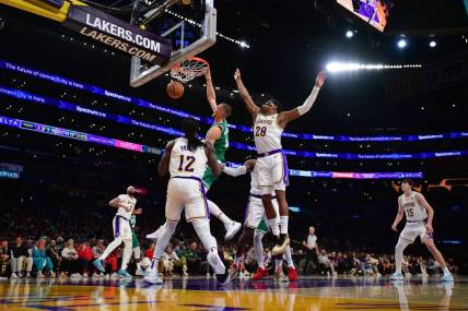 Dec 25, 2023; Los Angeles, California, USA; Boston Celtics center Kristaps Porzingis (8) dunks for the basket against Los Angeles Lakers forward Rui Hachimura (28) and forward Taurean Prince (12) during the second half at Crypto.com Arena. Mandatory Credit: Gary A. Vasquez-USA TODAY Sports