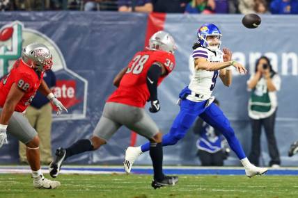 Dec 26, 2023; Phoenix, AZ, USA; Kansas Jayhawks quarterback Jason Bean (9) throws a pass against UNLV Rebels linebacker Marsel McDuffie (38) during the first quarter in the Guaranteed Rate Bowl at Chase Field. Mandatory Credit: Mark J. Rebilas-USA TODAY Sports