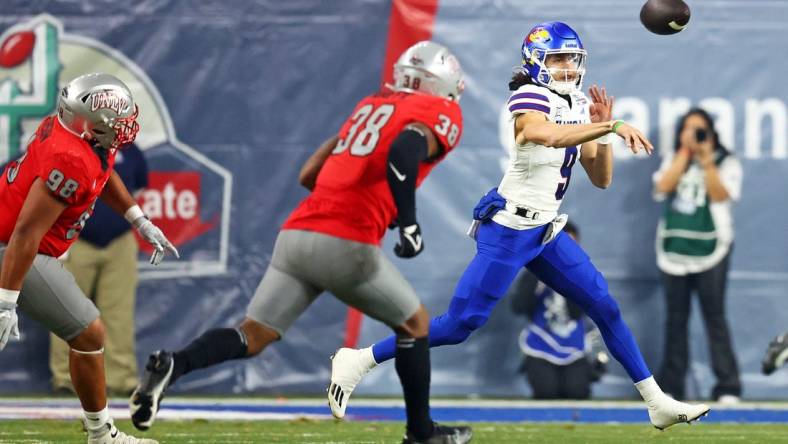 Dec 26, 2023; Phoenix, AZ, USA; Kansas Jayhawks quarterback Jason Bean (9) throws a pass against UNLV Rebels linebacker Marsel McDuffie (38) during the first quarter in the Guaranteed Rate Bowl at Chase Field. Mandatory Credit: Mark J. Rebilas-USA TODAY Sports