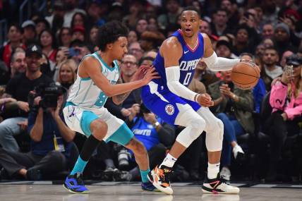 Dec 26, 2023; Los Angeles, California, USA; Los Angeles Clippers guard Russell Westbrook (0) moves the ball against Charlotte Hornets guard Nick Smith Jr. (8) during the first half at Crypto.com Arena. Mandatory Credit: Gary A. Vasquez-USA TODAY Sports