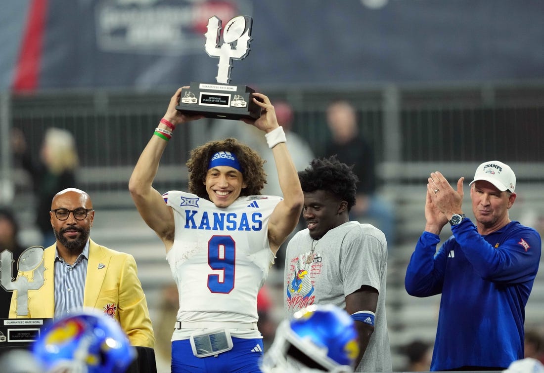 Dec 26, 2023; Phoenix, AZ, USA; Kansas Jayhawks quarterback Jason Bean (9) celebrates with the trophy after defeating the UNLV Rebels at Chase Field. Mandatory Credit: Joe Camporeale-USA TODAY Sports