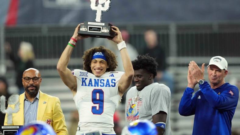 Dec 26, 2023; Phoenix, AZ, USA; Kansas Jayhawks quarterback Jason Bean (9) celebrates with the trophy after defeating the UNLV Rebels at Chase Field. Mandatory Credit: Joe Camporeale-USA TODAY Sports