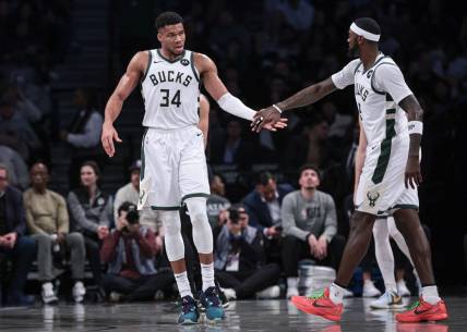 Dec 27, 2023; Brooklyn, New York, USA; Milwaukee Bucks forward Giannis Antetokounmpo (34) slaps hands with forward Bobby Portis (9) during the first half against the Brooklyn Nets at Barclays Center. Mandatory Credit: Vincent Carchietta-USA TODAY Sports