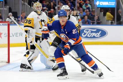 Dec 27, 2023; Elmont, New York, USA; New York Islanders left wing Anders Lee (27) skates against Pittsburgh Penguins goaltender Tristan Jarry (35) and defenseman Ryan Graves (27) during the second period at UBS Arena. Mandatory Credit: Brad Penner-USA TODAY Sports