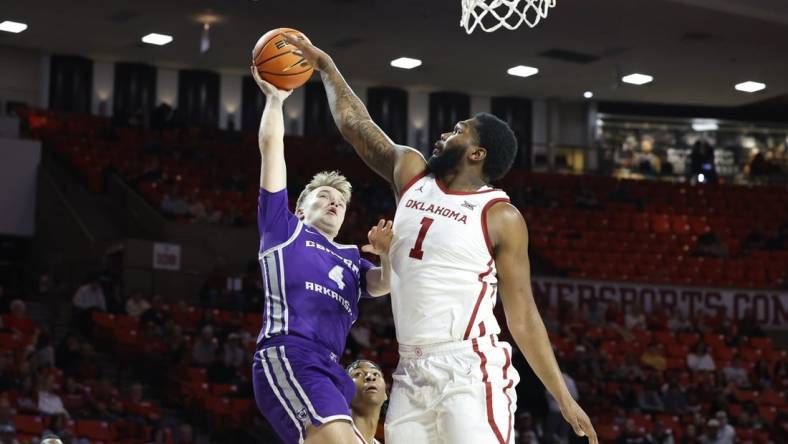 Dec 28, 2023; Norman, Oklahoma, USA; Central Arkansas Bears guard Johannes Kirsipuu (4) shoots as Oklahoma Sooners forward John Hugley IV (1) defends during the first half at Lloyd Noble Center. Mandatory Credit: Alonzo Adams-USA TODAY Sports