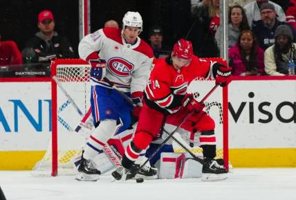 Dec 28, 2023; Raleigh, North Carolina, USA; Carolina Hurricanes center Seth Jarvis (24) and Montreal Canadiens center Sean Monahan (91) watch the shot during the second period at PNC Arena. Mandatory Credit: James Guillory-USA TODAY Sports