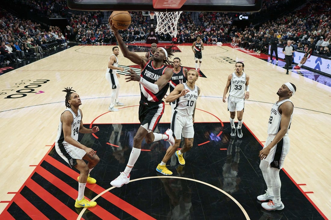 Dec 28, 2023; Portland, Oregon, USA; Portland Trail Blazers forward Jerami Grant (9) scores a basket during the second half against San Antonio Spurs forward Jeremy Sochan (10) at Moda Center. Mandatory Credit: Troy Wayrynen-USA TODAY Sports