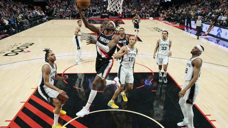 Dec 28, 2023; Portland, Oregon, USA; Portland Trail Blazers forward Jerami Grant (9) scores a basket during the second half against San Antonio Spurs forward Jeremy Sochan (10) at Moda Center. Mandatory Credit: Troy Wayrynen-USA TODAY Sports