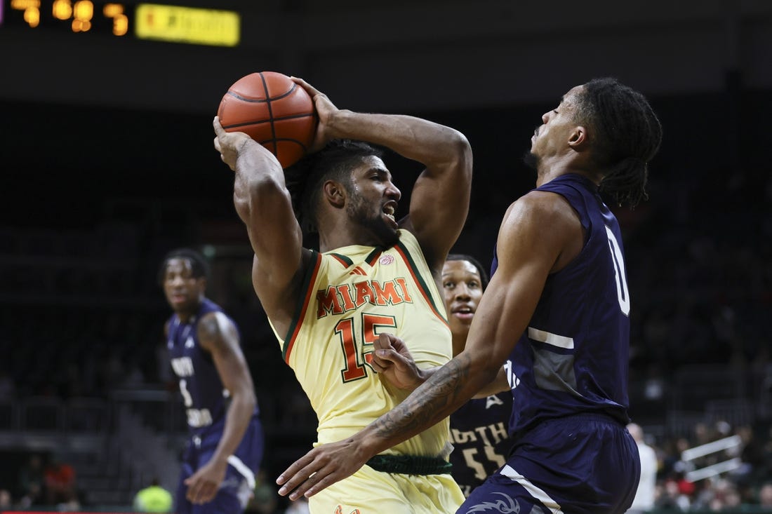 Dec 29, 2023; Coral Gables, Florida, USA; Miami Hurricanes forward Norchad Omier (15) protects the basketball from North Florida Ospreys guard Jasai Miles (0) during the first half at Watsco Center. Mandatory Credit: Sam Navarro-USA TODAY Sports