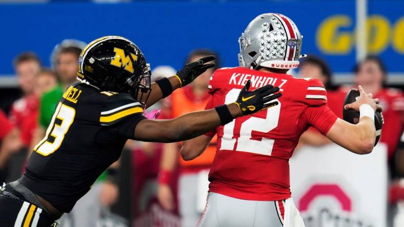 Dec 29, 2023; Arlington, Texas, USA; Ohio State Buckeyes quarterback Lincoln Kienholz (12) almost gets sacked by Missouri Tigers defensive back Daylan Carnell (13) before throwing the ball away in the second quarter during the Goodyear Cotton Bowl Classic at AT&T Stadium.