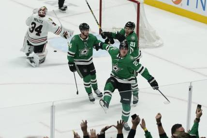 Dec 29, 2023; Dallas, Texas, USA; Dallas Stars center Roope Hintz (24) reacts with defenseman Miro Heiskanen (4) and left wing Jason Robertson (21) in front of Chicago Blackhawks goaltender Petr Mrazek (34) after scoring the game winning goal during overtime at American Airlines Center. Mandatory Credit: Raymond Carlin III-USA TODAY Sports