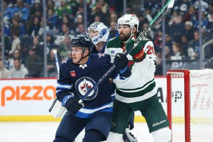 Dec 30, 2023; Winnipeg, Manitoba, CAN;  Winnipeg Jets defenseman Nate Schmidt (88) jostles for position with Minnesota Wild forward Patrick Maroon (20) in front of goaltender Connor Hellebuyck (37) during the first period at Canada Life Centre. Mandatory Credit: Terrence Lee-USA TODAY Sports