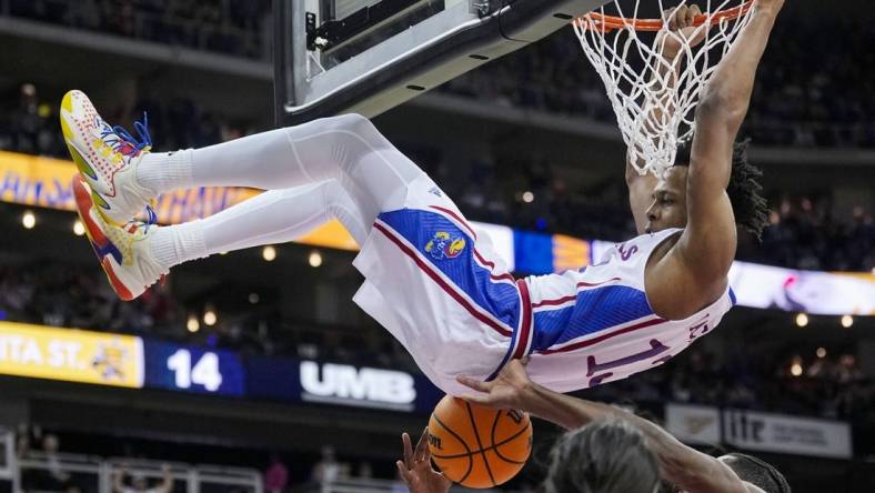 Dec 30, 2023; Kansas City, Missouri, USA; Kansas Jayhawks guard Elmarko Jackson (13) dunks against Wichita State Shockers center Quincy Ballard (15) and guard Bijan Cortes (55) during the first half at T-Mobile Center. Mandatory Credit: Jay Biggerstaff-USA TODAY Sports