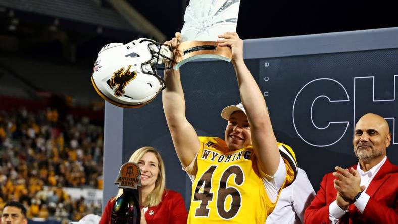 Dec 30, 2023; Tucson, AZ, USA; Wyoming Cowboys place kicker John Hoyland (46) celebrates with offensive MVP trophy after the Wyoming Cowboys beat the Toledo Rockets in the Arizona Bowl at Arizona Stadium. Mandatory Credit: Mark J. Rebilas-USA TODAY Sports