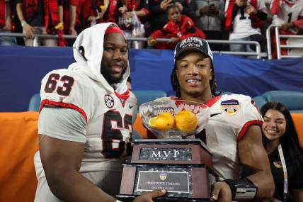 Dec 30, 2023; Miami Gardens, FL, USA; Georgia Bulldogs running back Kendall Milton (2) holds the MVP game trophy with offensive lineman Sedrick Van Pran (63)after the Capital One Orange Bowl at Hard Rock Stadium. Mandatory Credit: Nathan Ray Seebeck-USA TODAY Sports