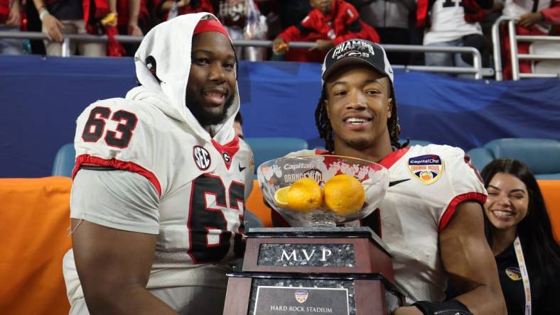 Dec 30, 2023; Miami Gardens, FL, USA; Georgia Bulldogs running back Kendall Milton (2) holds the MVP game trophy with offensive lineman Sedrick Van Pran (63)after the Capital One Orange Bowl at Hard Rock Stadium. Mandatory Credit: Nathan Ray Seebeck-USA TODAY Sports