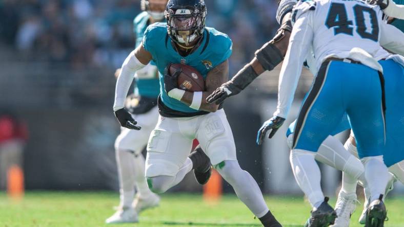 Dec 31, 2023; Jacksonville, Florida, USA; Jacksonville Jaguars running back Travis Etienne Jr. (1) runs the ball against the Carolina Panthers in the first quarter at EverBank Stadium. Mandatory Credit: Jeremy Reper-USA TODAY Sports