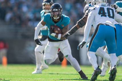 Dec 31, 2023; Jacksonville, Florida, USA; Jacksonville Jaguars running back Travis Etienne Jr. (1) runs the ball against the Carolina Panthers in the first quarter at EverBank Stadium. Mandatory Credit: Jeremy Reper-USA TODAY Sports