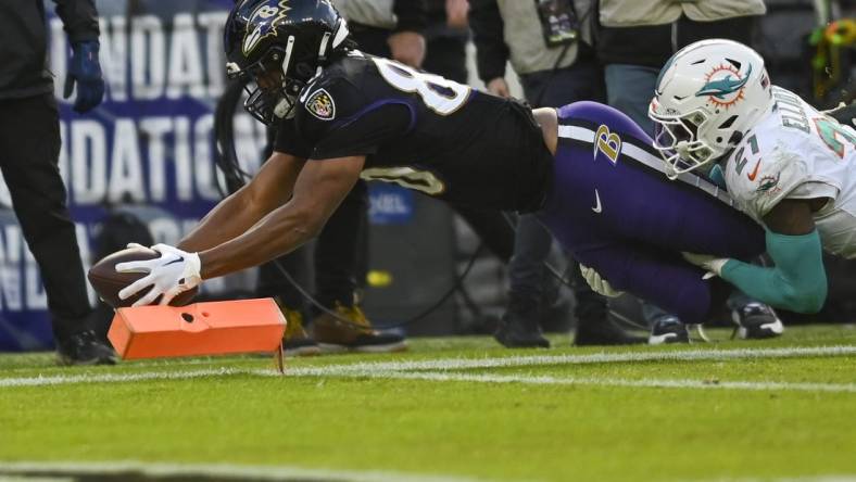 Dec 31, 2023; Baltimore, Maryland, USA;  Baltimore Ravens tight end Isaiah Likely (80) dives for a touchdown  as Miami Dolphins safety DeShon Elliott (21) defends during the first half at M&T Bank Stadium. Mandatory Credit: Tommy Gilligan-USA TODAY Sports