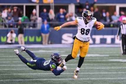 Dec 31, 2023; Seattle, Washington, USA; Pittsburgh Steelers tight end Pat Freiermuth (88) breaks a tackle attempt by Seattle Seahawks running back Zach Charbonnet (26) during the first half at Lumen Field. Mandatory Credit: Steven Bisig-USA TODAY Sports