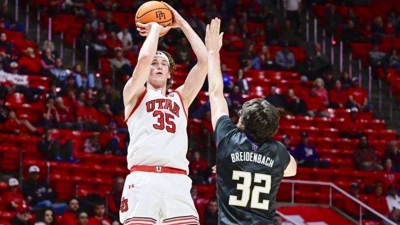 Dec 31, 2023; Salt Lake City, Utah, USA; Utah Utes center Branden Carlson (35) takes a shot over Washington Huskies forward Wilhelm Breidenbach (32) during the first half at the the Jon M. Huntsman Center. Mandatory Credit: Christopher Creveling-USA TODAY Sports