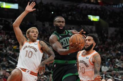 Dec 31, 2023; San Antonio, Texas, USA;  Boston Celtics guard Jaylen Brown (7) loses the ball in front of San Antonio Spurs forwards Jeremy Sochan (10) Julian Champagnie (30) in the first half at Frost Bank Center. Mandatory Credit: Daniel Dunn-USA TODAY Sports