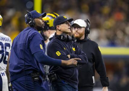 Dec 4, 2021; Indianapolis, IN, USA; Michigan Wolverines offensive line coach Sherrone Moore (left), head coach Jim Harbaugh (center) and special teams coordinator Jay Harbaugh against the Iowa Hawkeyes in the Big Ten Conference championship game at Lucas Oil Stadium. Mandatory Credit: Mark J. Rebilas-USA TODAY Sports