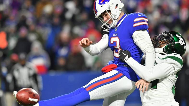 Jan 9, 2022; Orchard Park, New York, USA; Buffalo Bills punter Matt Haack (3) tries to punt the ball while under pressure by New York Jets defensive back Justin Hardee (34)  in the third quarter at Highmark Stadium. Mandatory Credit: Mark Konezny-USA TODAY Sports