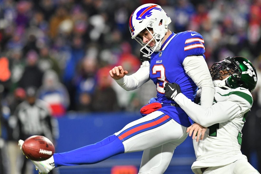 Jan 9, 2022; Orchard Park, New York, USA; Buffalo Bills punter Matt Haack (3) tries to punt the ball while under pressure by New York Jets defensive back Justin Hardee (34)  in the third quarter at Highmark Stadium. Mandatory Credit: Mark Konezny-USA TODAY Sports