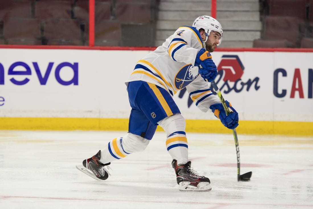 Jan 18, 2022; Ottawa, Ontario, CAN; Buffalo Sabres defenseman Will Butcher (4) shoots the puck in the second period against the Ottawa Senators at the Canadian Tire Centre. Mandatory Credit: Marc DesRosiers-USA TODAY Sports