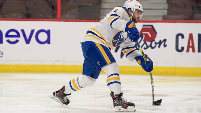 Jan 18, 2022; Ottawa, Ontario, CAN; Buffalo Sabres defenseman Will Butcher (4) shoots the puck in the second period against the Ottawa Senators at the Canadian Tire Centre. Mandatory Credit: Marc DesRosiers-USA TODAY Sports