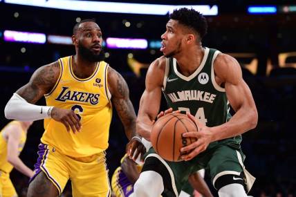 Feb 8, 2022; Los Angeles, California, USA; Milwaukee Bucks forward Giannis Antetokounmpo (34) moves the ball against Los Angeles Lakers forward LeBron James (6) during the second half at Crypto.com Arena. Mandatory Credit: Gary A. Vasquez-USA TODAY Sports