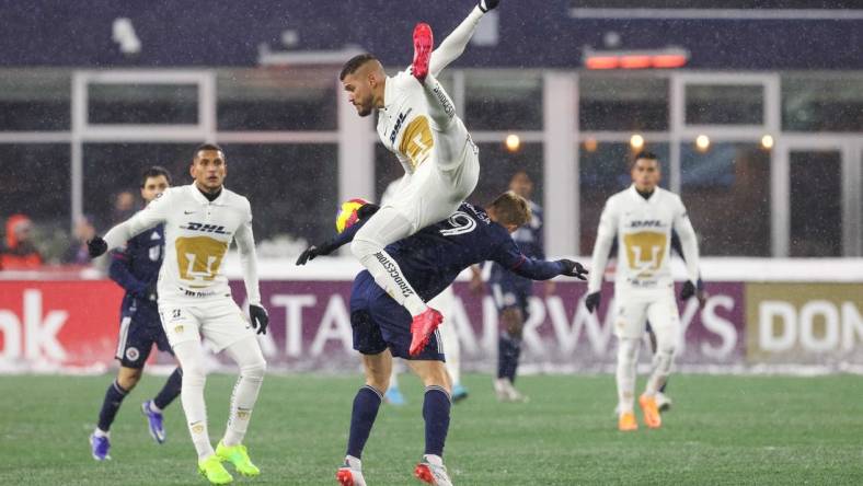 Mar 9, 2022; Foxborough, Massachusetts, USA; Pumas UNAM defender Nicolas Freire (23) heads the ball over New England Revolution forward Adam Buksa (9) during the second half at Gillette Stadium during the 2022 CONCACAF Champions League Quarterfinals. Mandatory Credit: Paul Rutherford-USA TODAY Sports