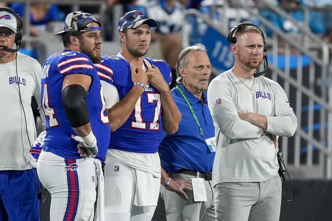 Aug 26, 2022; Charlotte, North Carolina, USA; Buffalo Bills guard Greg Van Roten (64), quarterback Josh Allen (17) and offensive coach Joe Brady watch as Carolina Panthers quarterback Sam Darnold (not pictured) is carted off the field during the second half at Bank of America Stadium. Mandatory Credit: Jim Dedmon-USA TODAY Sports